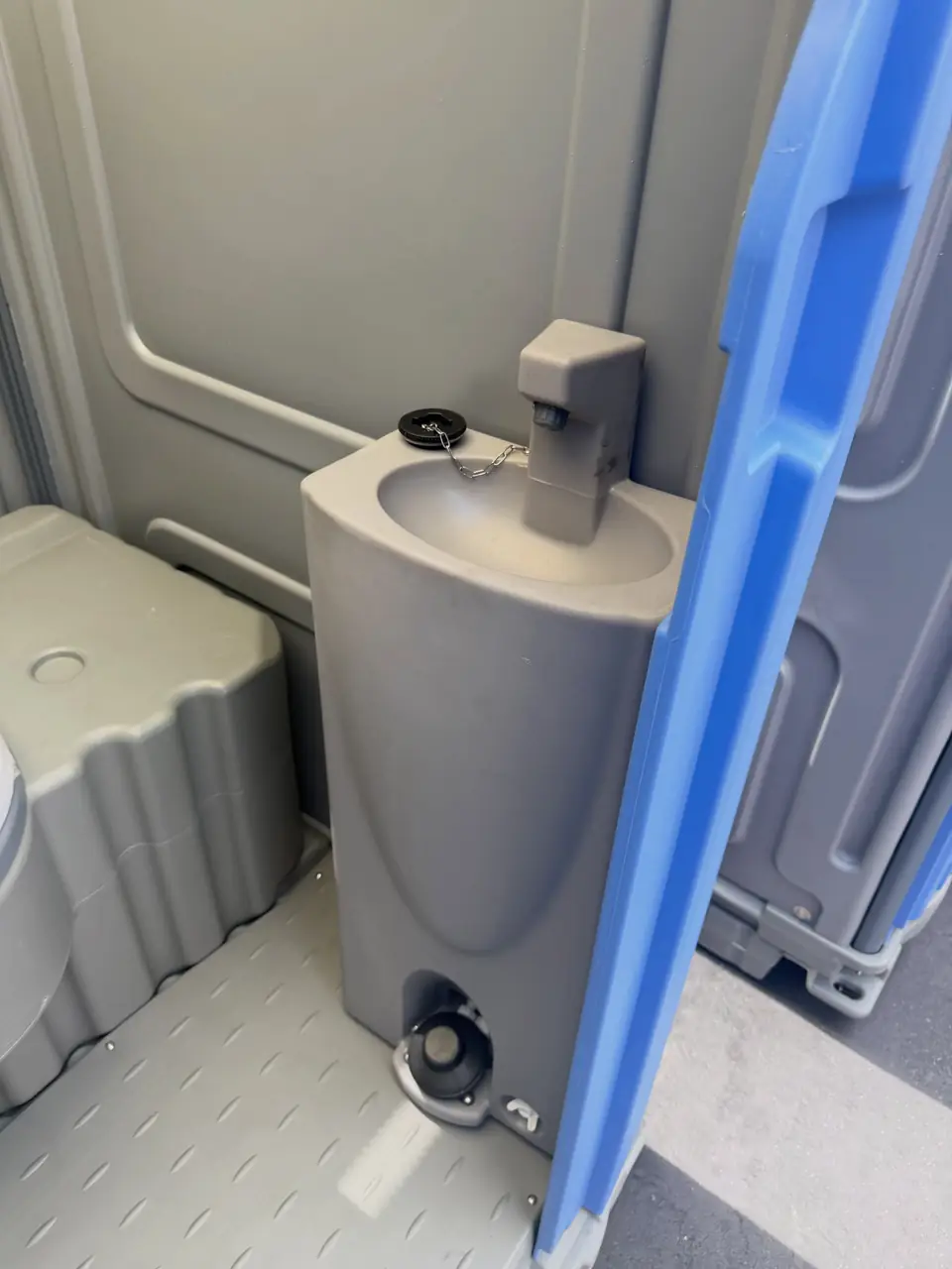 Foot-pump sink with soap dispenser inside a deluxe portable toilet