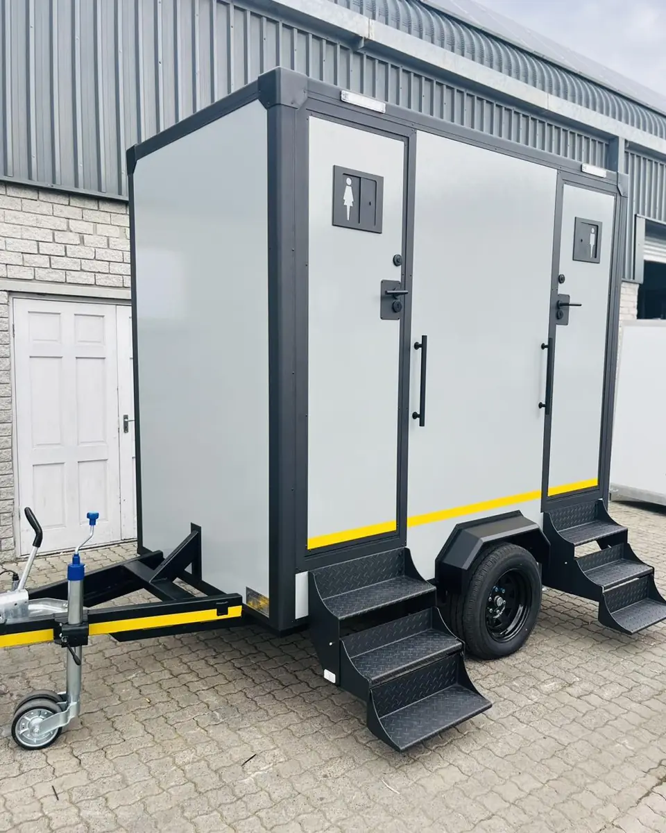 Compact two-door restroom trailer with steps and handrails